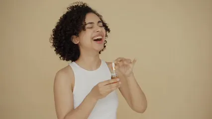 Horizontal video: A woman laughing with a bottle of essential oil on hand 6706911. Duration: 14 seconds. Resolution: 1920x1080