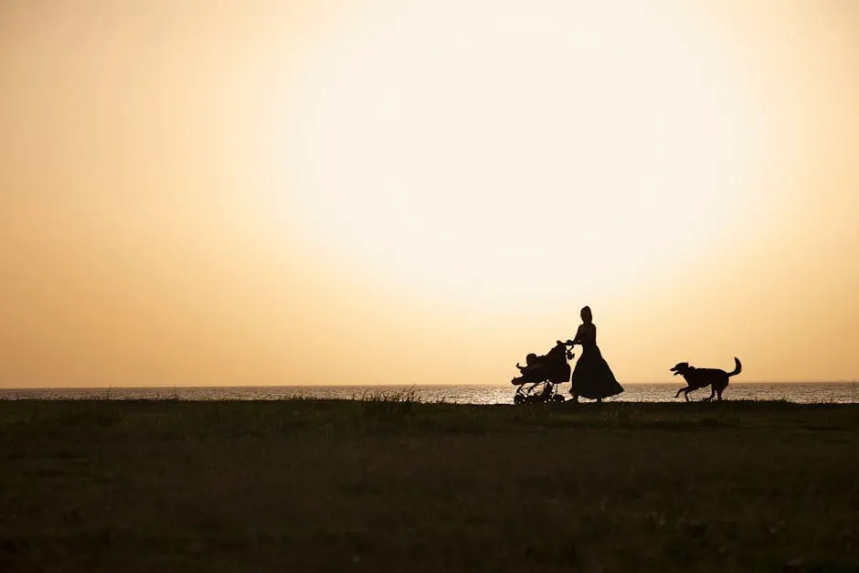 Woman with Stroller and Dog on Sea Shore under Yellow Sky at Sunset