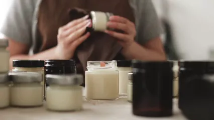 Horizontal video: Woman wiping candle jars clean 6754435. Duration: 8 seconds. Resolution: 3840x2160