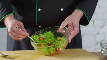 Horizontal video: A chef tossing the vegetables salad in a bowl to spread the dressing 3195728. Duration: 11 seconds. Resolution: 3840x2160