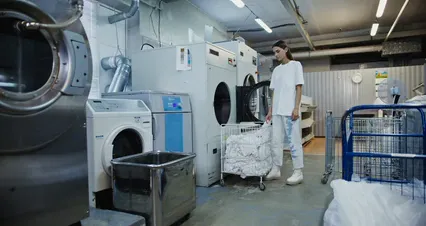 Horizontal video: Woman putting towels in a washing machine 8756941. Duration: 18 seconds. Resolution: 4096x2160
