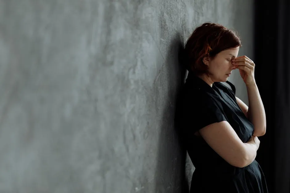 A Stressed Woman Leaning on a Concrete Wall