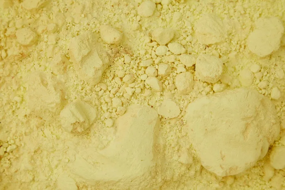 Full frame top view of clean yellow sand with ribbed stones chaotically spread around