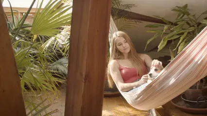Horizontal video: Woman sitting on the hammock with her dog 8056537. Duration: 8 seconds. Resolution: 3840x2160