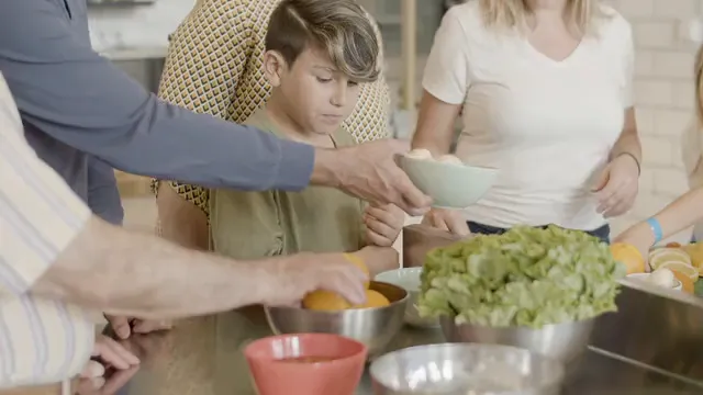 Horizontal video: Children eating orange slices in a kitchen with mom and grandma 8480197. Duration: 13 seconds. Resolution: 3840x2160