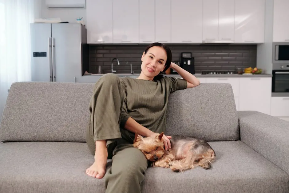 A Woman Sitting on a Couch Beside Her Brown Cute Puppy