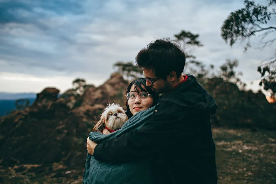 A couple enjoys a heartfelt moment with their Shih Tzu dog amidst a scenic landscape, depicting love and togetherness.