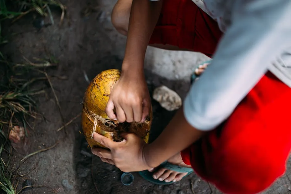 Person Peeling a Coconut