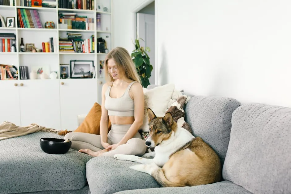 Beautiful Woman Meditating on Sofa Next to Dog