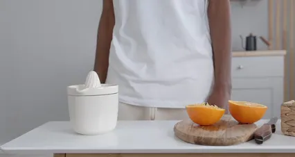 Horizontal video: Orange is squeeze in a citrus juicer 7117849. Duration: 26 seconds. Resolution: 4096x2160