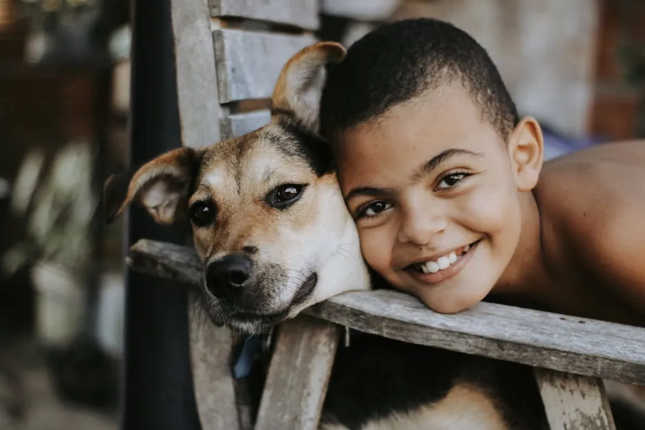 A smiling boy embraces his dog, showcasing friendship and happiness.