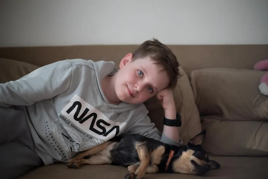 A young boy relaxes on a couch with a sleeping puppy, showcasing a serene moment of companionship indoors.