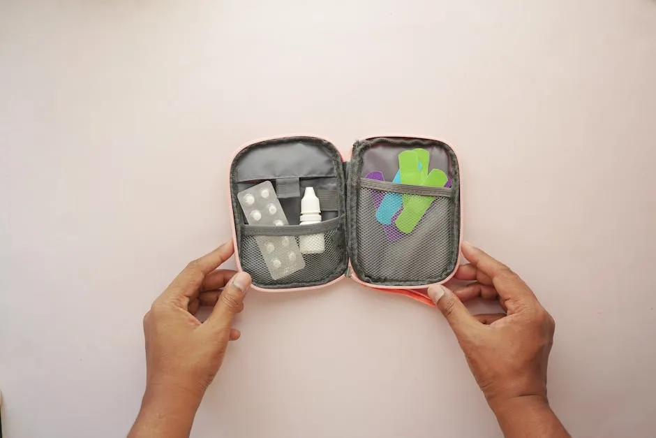 Open first aid kit containing band aids, tablets, and medicines, held by hands.