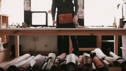 Horizontal video: Man putting a roll of leather on the table 4456110. Duration: 8 seconds. Resolution: 1920x1080