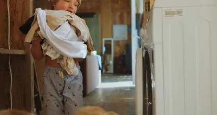 Horizontal video: Boy putting clothes into washing machine 7086403. Duration: 6 seconds. Resolution: 4096x2160