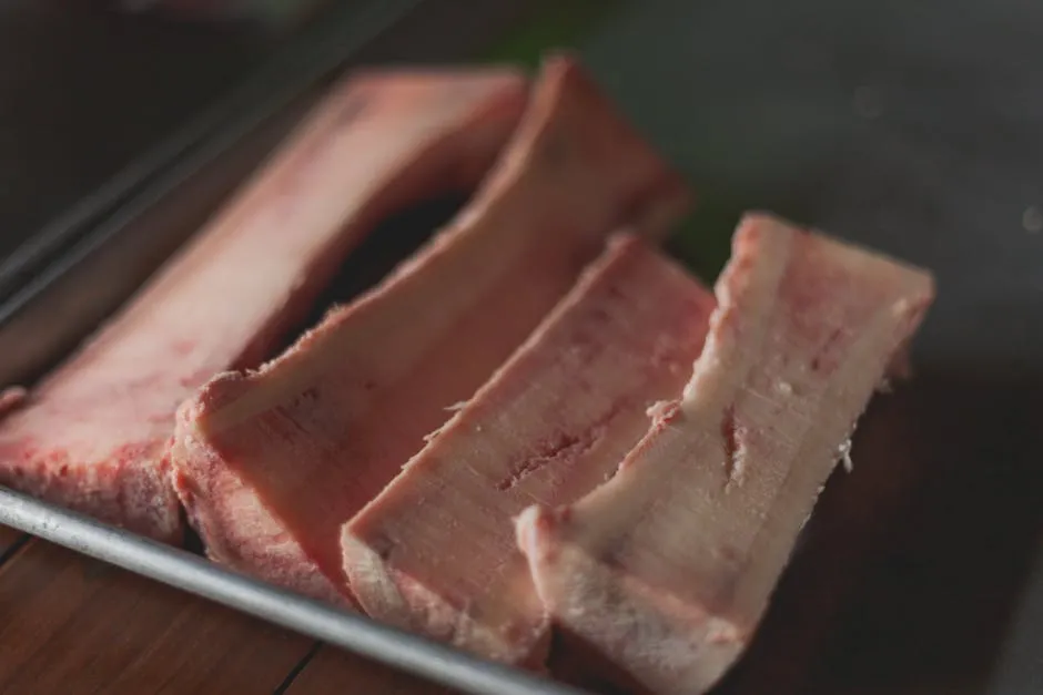 High-quality close-up image of raw beef bone marrow slices on a tray, perfect for cooking concepts.