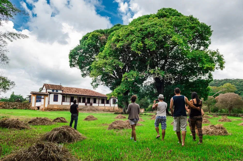 A group of adults enjoying an outdoor walk near a farmhouse surrounded by nature.